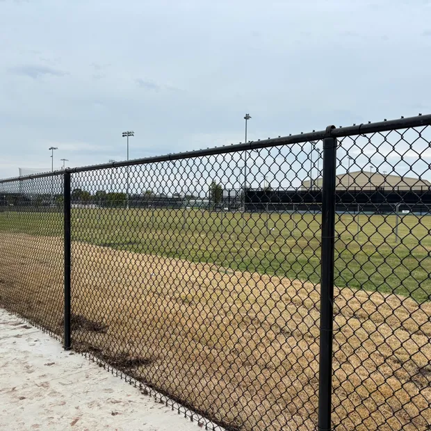 Black vinyl-coated chain-link fence installed around an athletic field