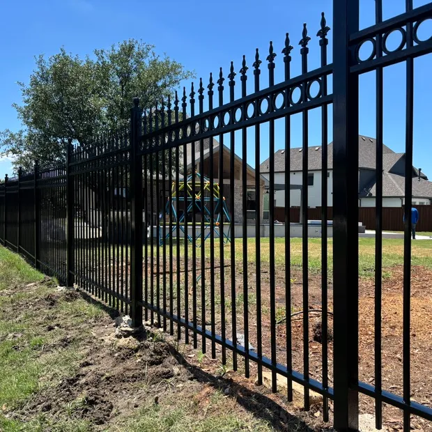 Black ornamental steel fence with spear-top pickets around a property