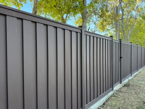 Charcoal Trex composite privacy fence with vertical interlocking pickets and a matching gate